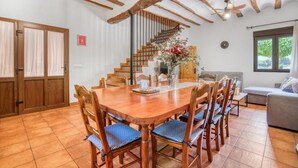 Een eethoek met een houten tafel en stoelen, een trap en een bank.