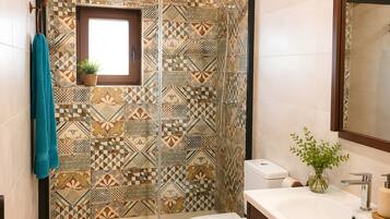 Un baño con ducha, inodoro y lavamanos.