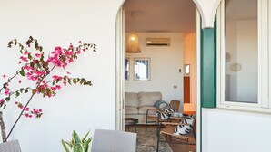 Un espace intérieur comprenant une table à manger, des chaises, une plante en pot et un canapé à l’arrière-plan.