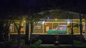 A stone building with a porch, steps, and a small garden area. - Bandhavgarh Meadows (Manpur)