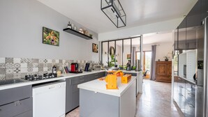 Cozinha moderna com ilha central, lava-louças embutida e diversos eletrodomésticos.