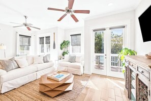 A spacious living room with a white sofa, a coffee table, and a ceiling fan.