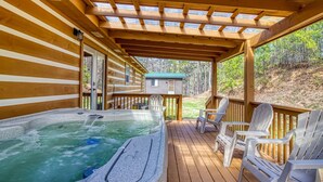 A wooden deck with a hot tub, outdoor chairs, and a covered area with a view of a cabin. - Hilltop Hideaway - 3 Bedroom 2 Bath - Private! (Sevierville)