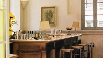 Une cuisine dotée d’un îlot central, de tabourets de bar, d’un tableau encadré et d’une fenêtre avec des volets.