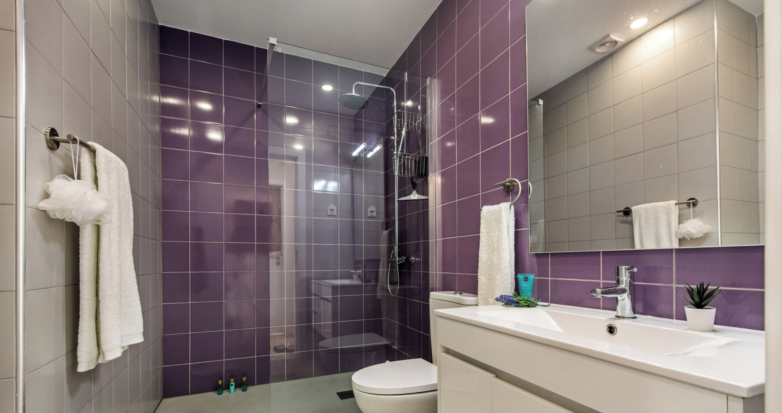 Un baño moderno con ducha, inodoro y lavamanos.