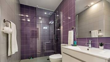 Un baño moderno con ducha, inodoro y lavamanos.