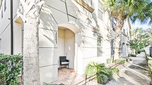 Residential building with a clean, minimalist design, featuring a small porch and well-manicured grounds.