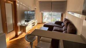 Un salon moderne avec un canapé, un téléviseur et une table à manger.