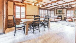 A spacious living room with a wooden dining table, four chairs, a sofa, and a fireplace. - Luxury Cabin*Gym*Game Room*Fireplace (Lehighton)