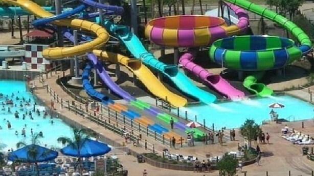 Un parque acuático con varias toboganes de agua y una zona de piscina.