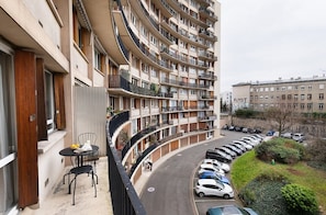 Stylish building with curved balconies and a ground-floor seating area.
