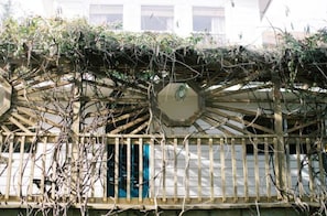Un bâtiment doté d’un balcon en bois et d’une fenêtre circulaire.