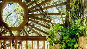 A wooden deck with a hexagonal wooden frame and a potted plant with green leaves. - Master Suite at the Honeycomb (shared house) (San Marcos)