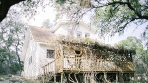 A white house with a wooden porch covered in vines. - Honey Comb Guest Suite (shared house) (San Marcos)