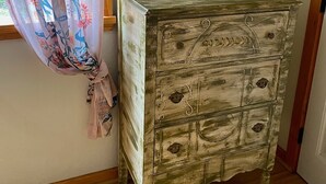 A room with a wooden dresser, a mirror, and a window with floral curtains. - Honey Comb Guest Suite (shared house) (San Marcos)