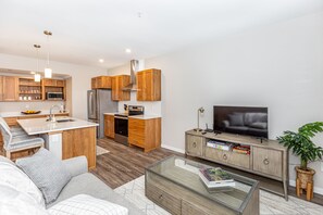 A modern kitchen with wooden cabinets, a stainless steel refrigerator, and a built-in microwave.