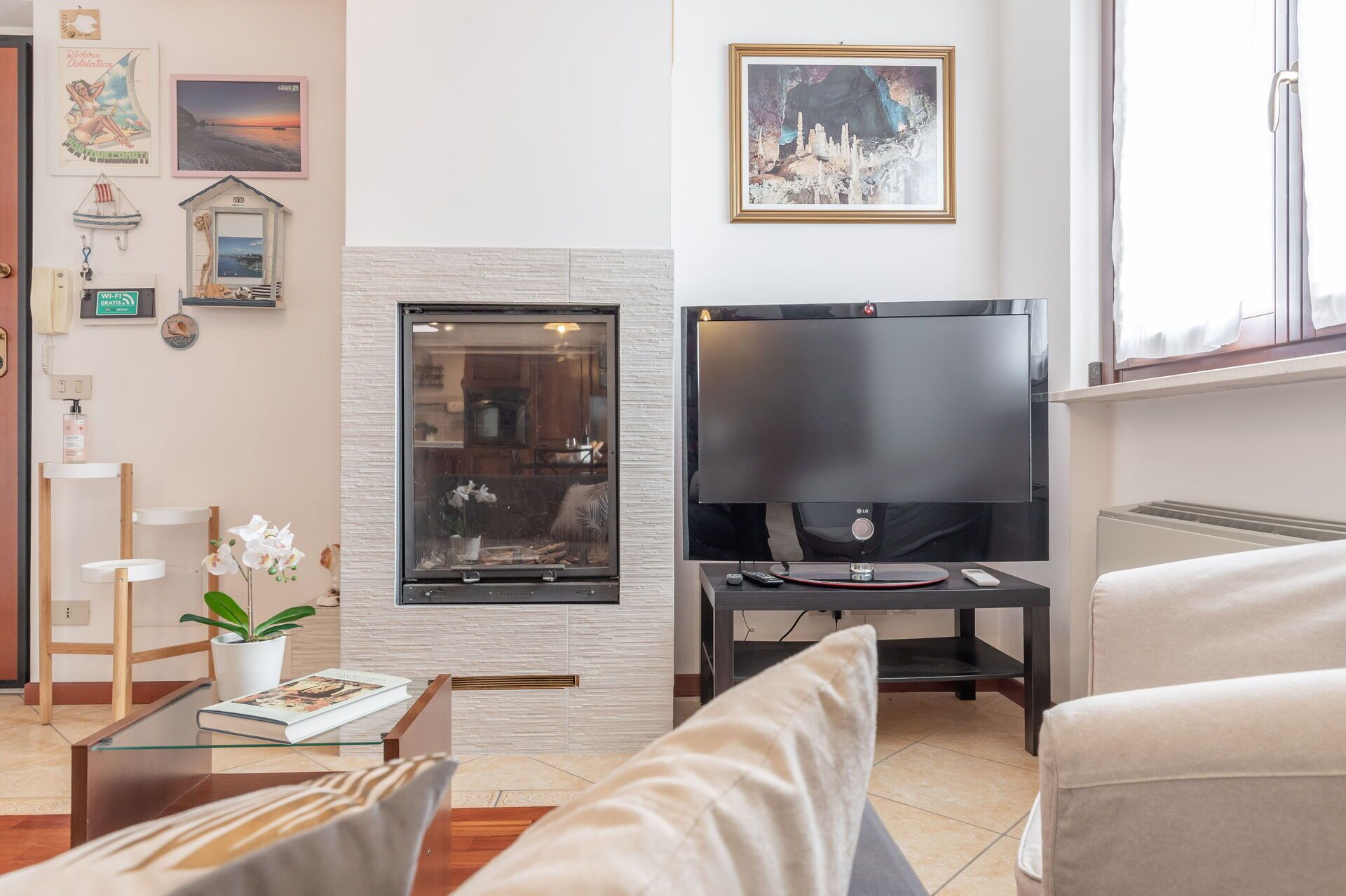 A living room with a fireplace, a flat-screen TV, a sofa, and a coffee table.