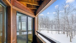 A wooden cabin with a large window overlooking a snowy forest. - Two-Bedroom Condo with Stunning Views and Prime Location A4 (Killington)
