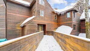 A wooden cabin with a snow-covered exterior and a narrow snow-filled pathway. - Two-Bedroom Condo with Stunning Views and Prime Location A4 (Killington)
