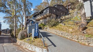 A hotel named KARAS with a stone pathway leading to the entrance, surrounded by trees and a hillside.
