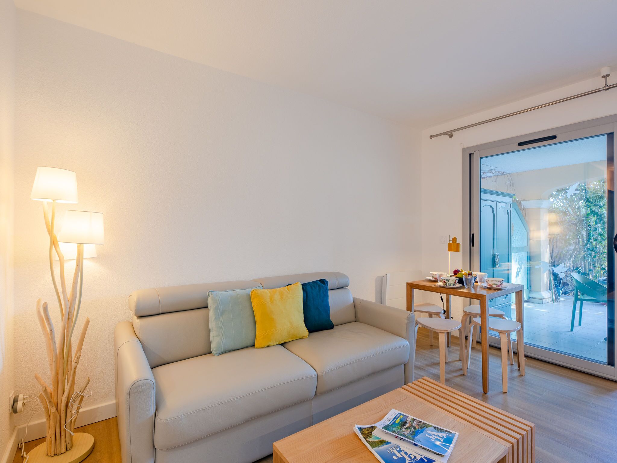 Een moderne woonkamer met een bank, een salontafel en een eethoek met stoelen.