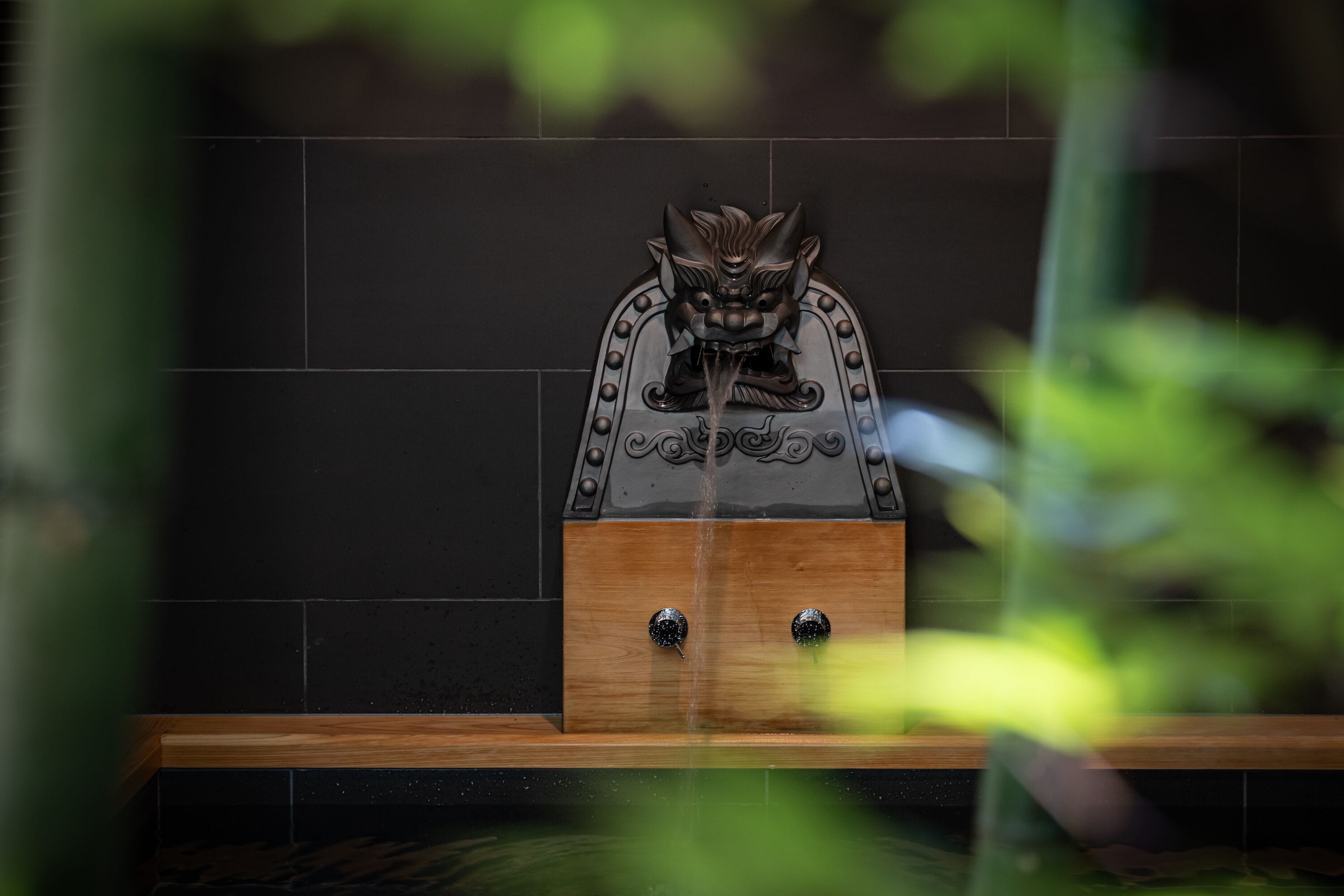 Een badkamer met een decoratieve douchekop en een houten plank.