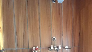 A wooden shower enclosure with a rain showerhead and a handheld showerhead. - Tribeni Lodge Restaurant And Bar (Phakding)