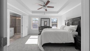Quarto com cama, cómoda, ventoinha no teto e closet espaçoso.
