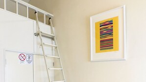 A white ladder leaning against a white cabinet with a no-smoking sign, a framed abstract painting on the wall, and a wooden floor. - Best room in Kawagoe (Kawagoe)