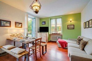 A living room with a dining table, sofa, and a TV.