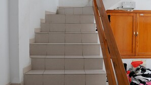 Una escalera con peldaños color beige y barandilla de madera.