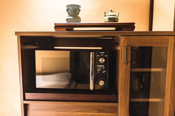 Un four à micro-ondes en bois, doté d’une porte en verre et d’un panneau de commande.