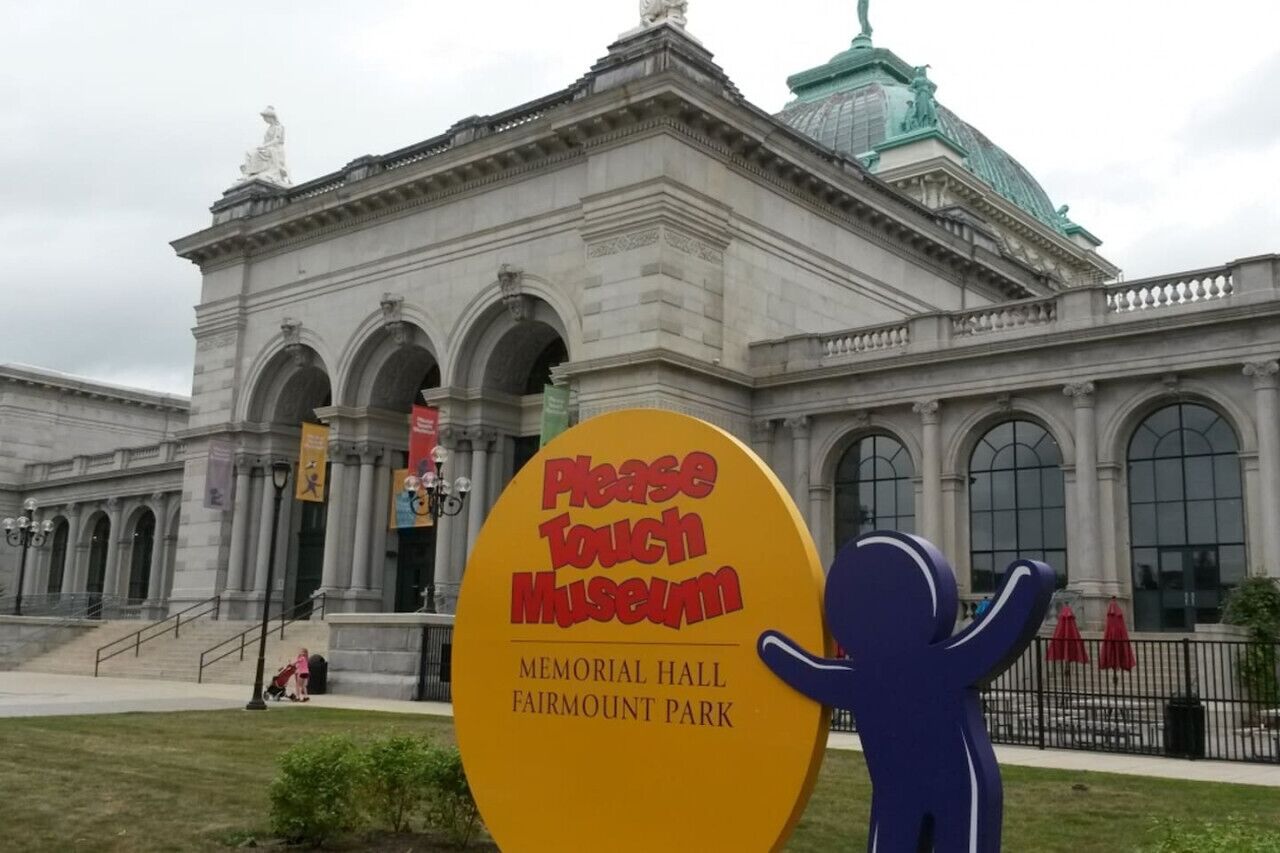 Un edificio con una entrada amplia y un letrero que dice 'Please Touch Museum'.