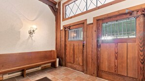 Eine Holztür mit Fenster, eine Bank und eine Wandleuchte.