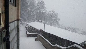 A snowy scene with a building and a covered area, possibly a parking lot or entrance, with a staircase leading up. - Hotel Amar Palace (Shimla)