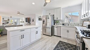 A modern kitchen with white cabinetry, stainless steel appliances, and a central island. - 5BR Retreat w/ Salt Water Pool, Spa, Fire Pit &BBQ (San Diego)