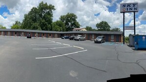 A motel with a covered parking area, multiple rooms, and a sign for 'Sky Inn'. - Sky Inn Hotel (Birmingham)