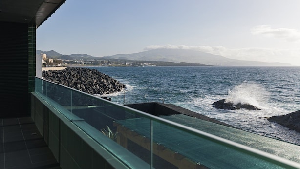 A balcony with a view of the sea and rocky coastline. - SeaLux Apartment - Seaside (Ponta Delgada)