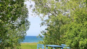Una mesa de picnic ubicada en un área verde con vistas al mar.