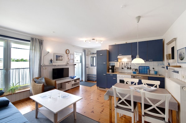 Um apartamento moderno com sala de estar, área de jantar e cozinha.