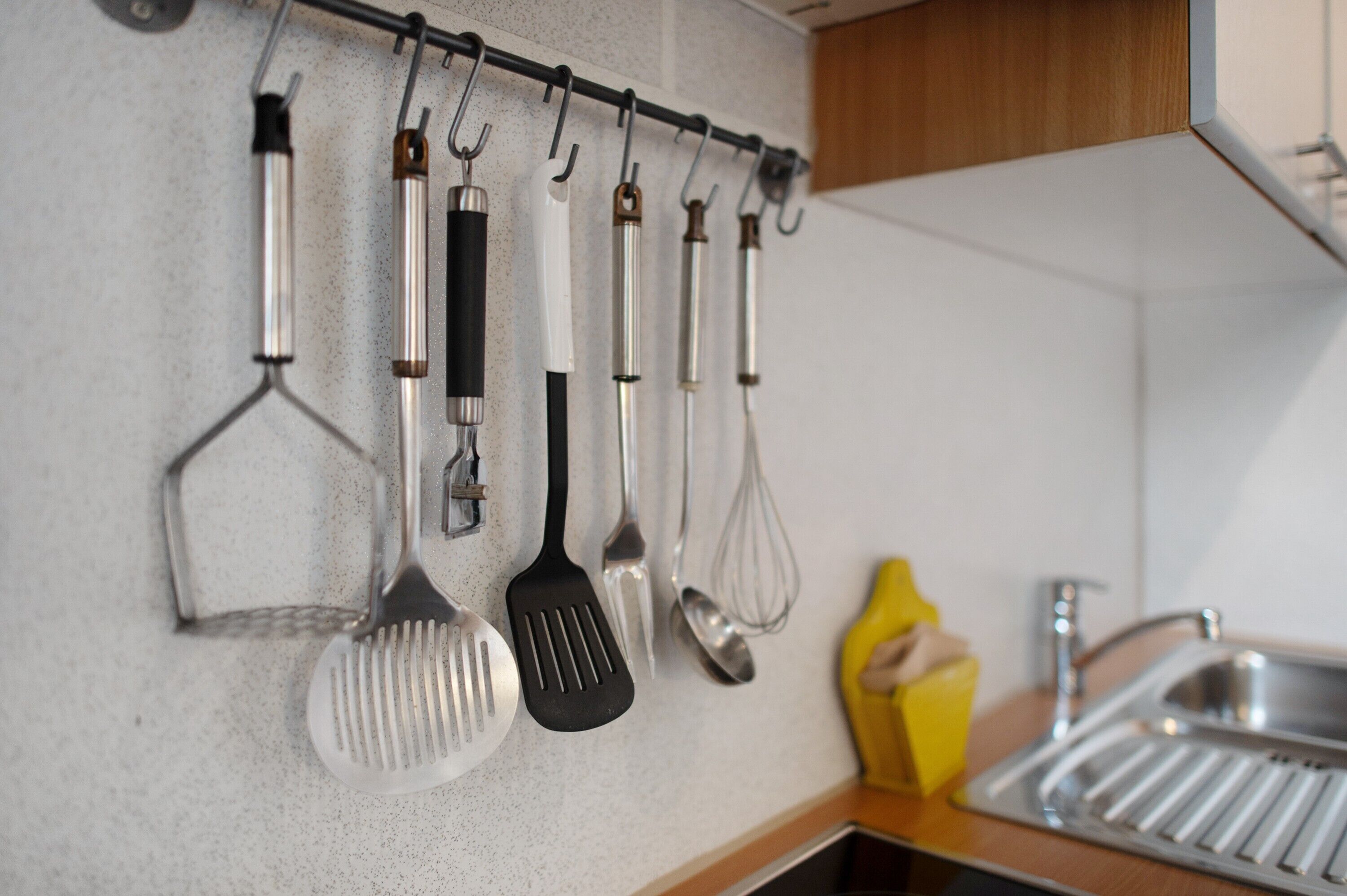 A kitchen with a utensil rack holding various kitchen tools.