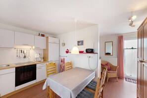 Eine kleine Küche mit Esstisch, Stühlen und einem kleinen Kühlschrank.