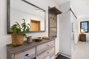 A bathroom vanity with a large mirror, wooden drawers, a woven basket, and a bowl. - Apartment 'Obsthof Fieß' with Private Terrace and Wi-Fi (Oberkirch)