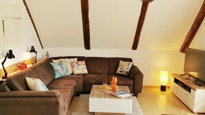 A living room with a brown sofa, a white coffee table, and a TV stand.