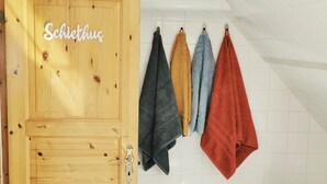 A wooden door with the name 'Schiethus' and four towels hanging on a rack.