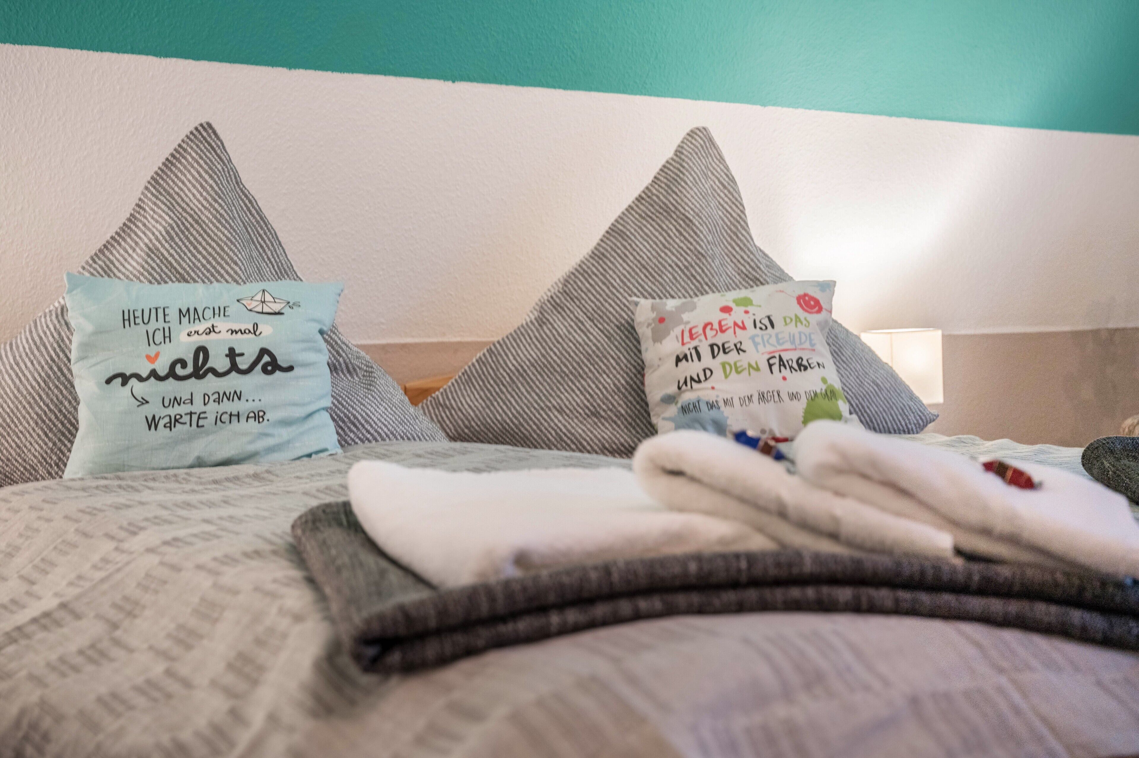 A bed with pillows and folded blankets.