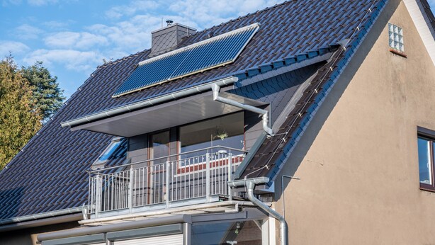 A house with a sloped roof, solar panels, a balcony with a railing, and a window. - Apartment 'Haus Heidorn' with Balcony and Wi-Fi (Sittensen)