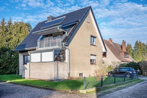 Et moderne hus med saddeltag, solpaneler, en balkon og en garage.