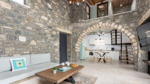A stone-walled interior with a dining area, kitchen, and a loft space. - La Casa Di Pietre 3 in Rhodes (Rhodes)