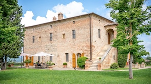 A historic brick building with a central staircase, outdoor seating, and a well-maintained garden. - Il Poggio Alle Trese 14 Emma Villas (Citta della Pieve)